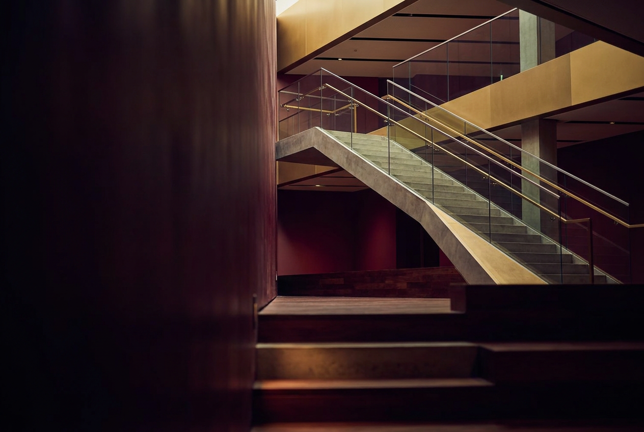 Warm, modern architectural interior with an upward-sweeping staircase